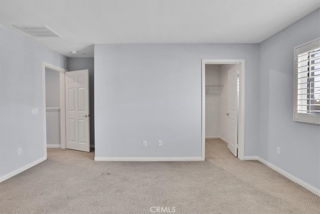 unfurnished bedroom with visible vents, baseboards, carpet, and a spacious closet