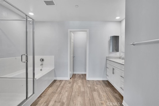 full bath featuring vanity, wood finished floors, visible vents, a stall shower, and a garden tub