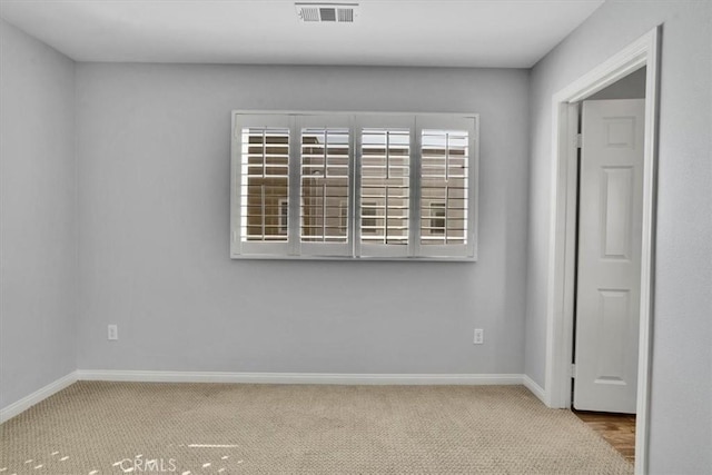 carpeted empty room with visible vents and baseboards