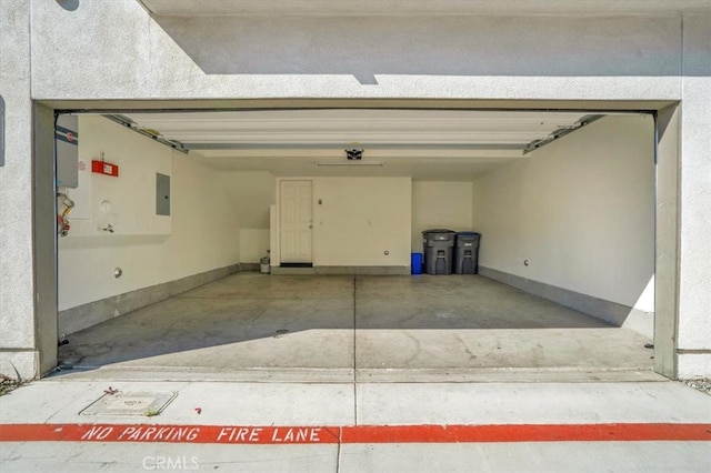 garage with electric panel and baseboards