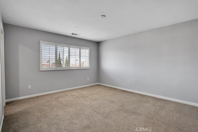 unfurnished room with visible vents, carpet floors, and baseboards