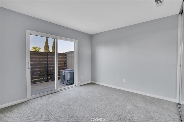 carpeted empty room with visible vents and baseboards