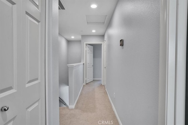 hallway featuring visible vents, light carpet, recessed lighting, baseboards, and attic access