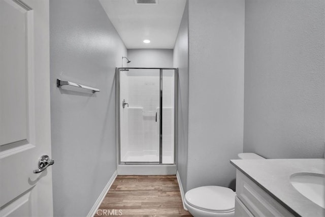 full bath with a shower stall, vanity, baseboards, and wood finished floors