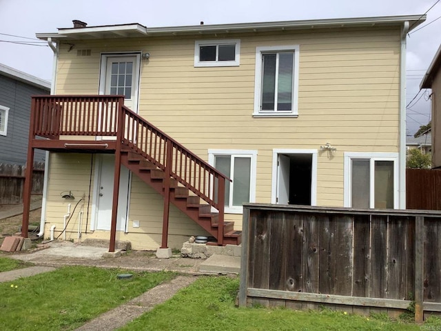 back of property featuring stairway and fence