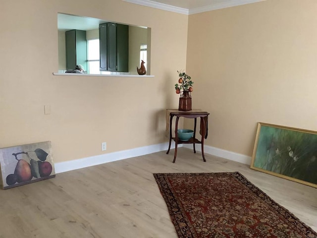 interior space featuring wood finished floors, baseboards, and ornamental molding