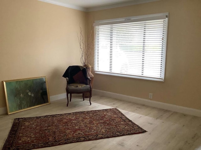 living area with crown molding, baseboards, and wood finished floors