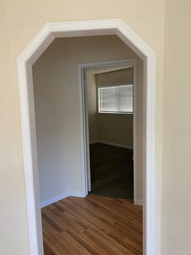 hall featuring wood finished floors and baseboards