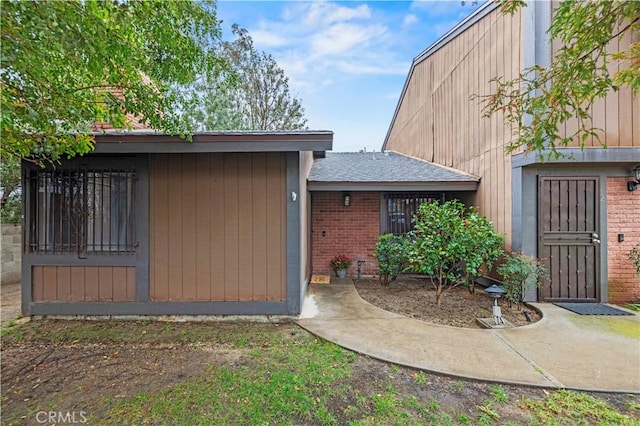 back of property featuring brick siding