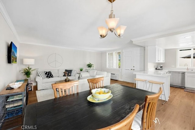 dining room featuring a notable chandelier, an AC wall unit, light wood-style floors, and ornamental molding