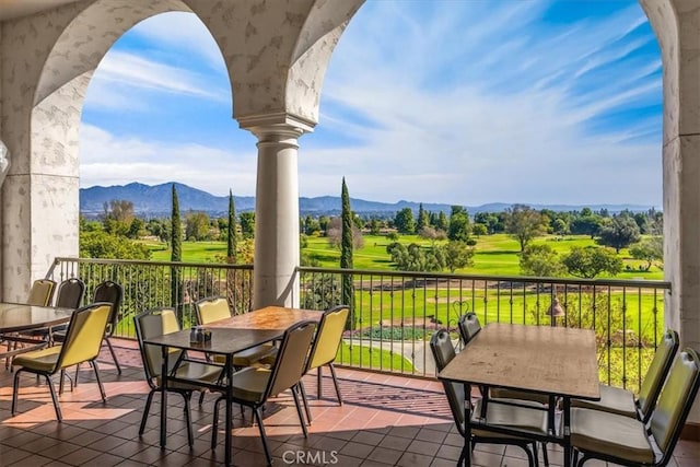 view of patio featuring outdoor dining area, a balcony, and a mountain view