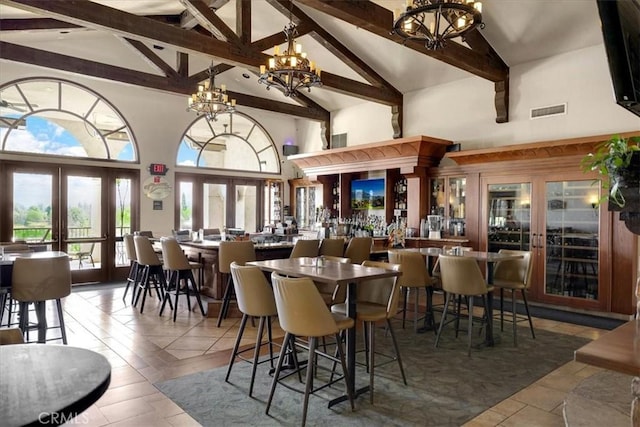 dining area featuring visible vents, a chandelier, beam ceiling, french doors, and high vaulted ceiling