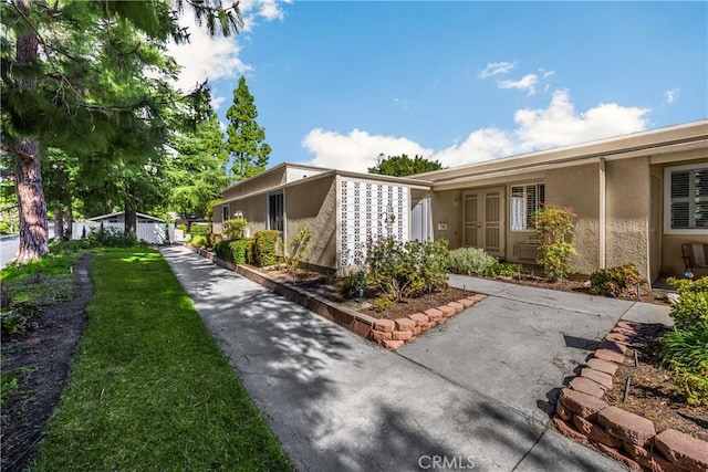 view of side of home with a lawn and stucco siding