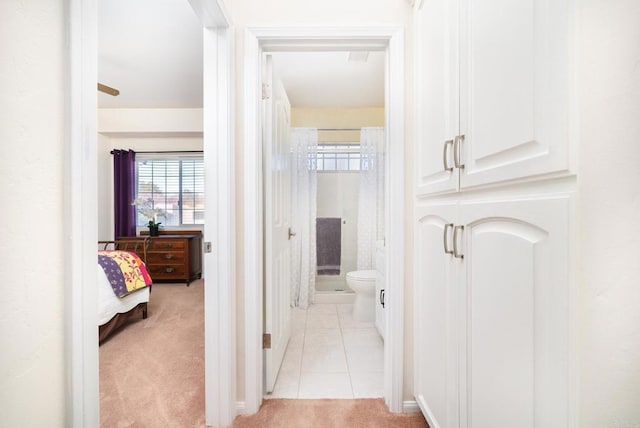 hallway featuring light carpet and light tile patterned floors