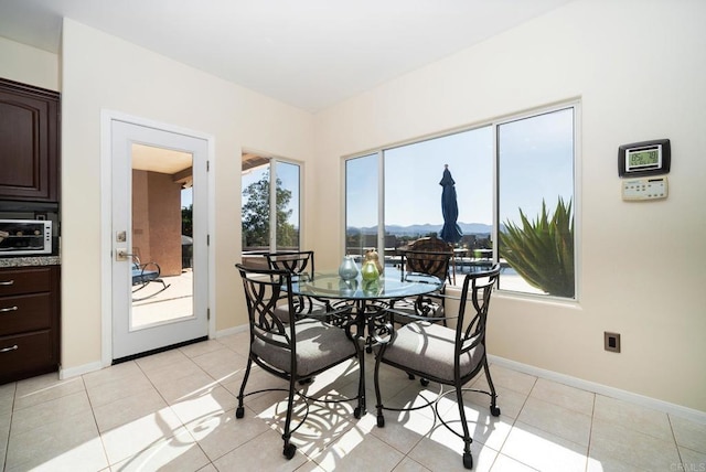 dining room with light tile patterned floors and baseboards