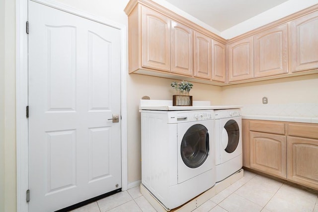 washroom with light tile patterned flooring, cabinet space, and independent washer and dryer