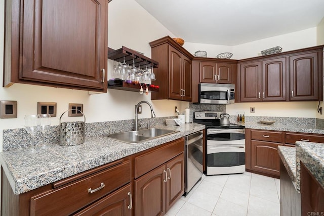 kitchen with light tile patterned flooring, appliances with stainless steel finishes, and a sink