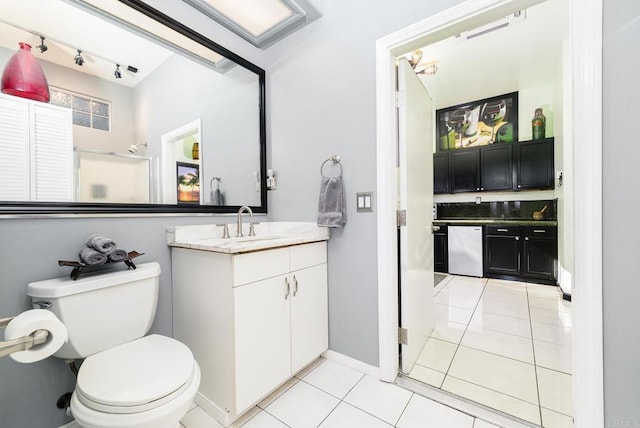 full bathroom with vanity, tile patterned flooring, rail lighting, an enclosed shower, and toilet