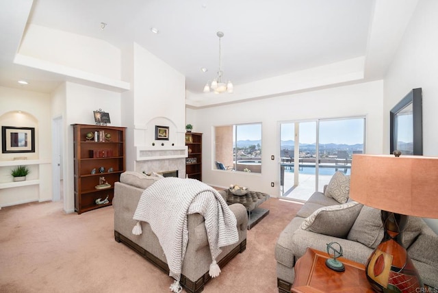 bedroom featuring access to exterior, light carpet, a fireplace, an inviting chandelier, and a raised ceiling