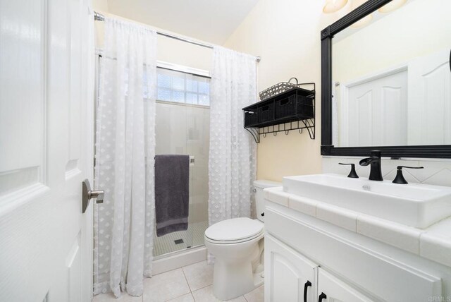 bathroom featuring vanity, tile patterned floors, toilet, and a stall shower