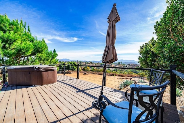 deck with a mountain view and a hot tub