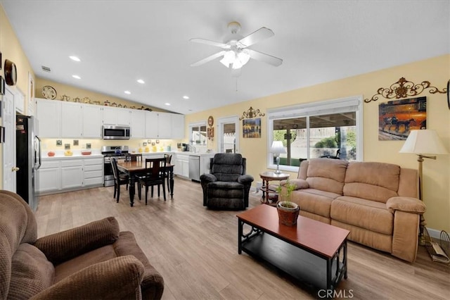 living area with light wood finished floors, visible vents, vaulted ceiling, recessed lighting, and a ceiling fan