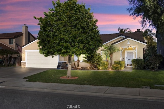 view of front facade with stucco siding, driveway, stone siding, a yard, and a garage