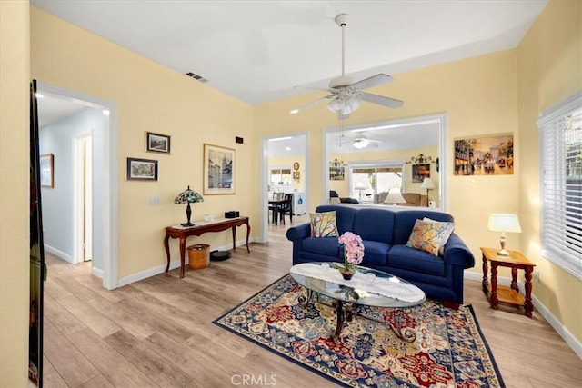 living area with plenty of natural light, light wood-style floors, visible vents, and baseboards