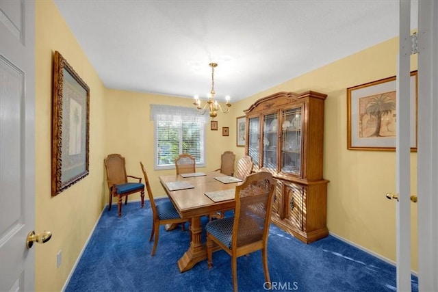 dining room featuring a chandelier, baseboards, and carpet floors