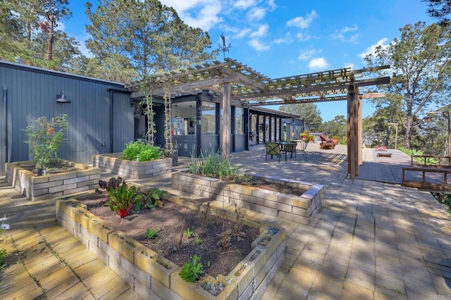 wooden deck with a pergola and a vegetable garden