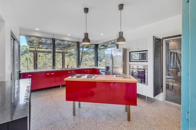 kitchen featuring a sink, butcher block countertops, light speckled floor, and stainless steel appliances