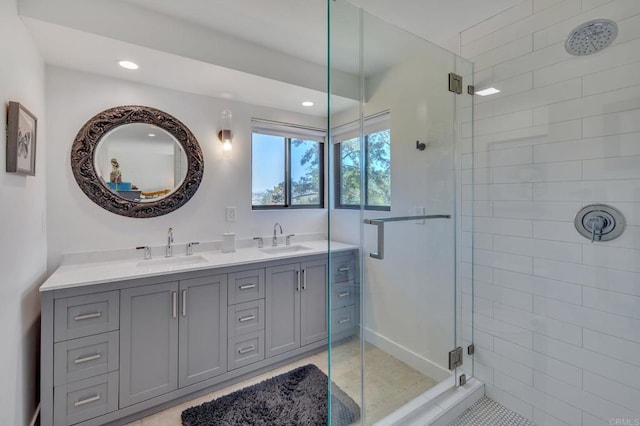 bathroom featuring a sink, recessed lighting, a stall shower, and double vanity