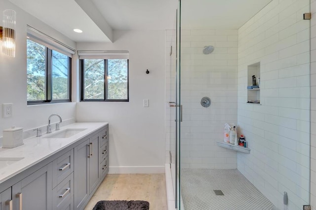 bathroom featuring a shower stall, baseboards, and a sink