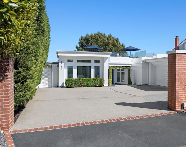 view of front of property with stucco siding, driveway, and a garage