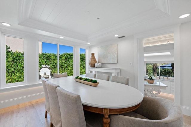 dining area featuring visible vents, ornamental molding, wood finished floors, recessed lighting, and a raised ceiling