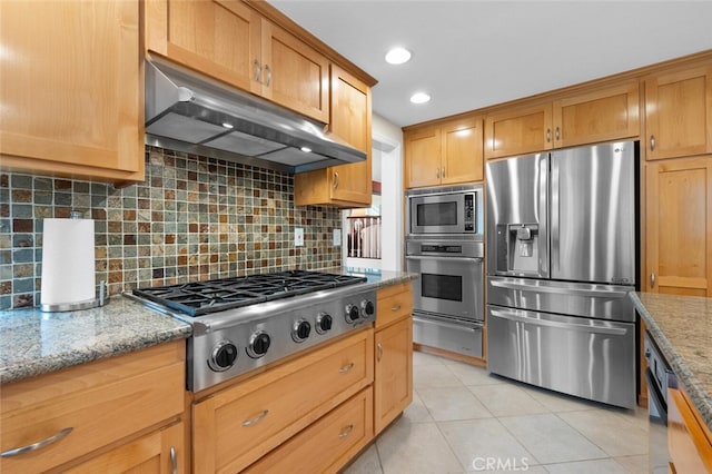 kitchen featuring backsplash, under cabinet range hood, light tile patterned floors, appliances with stainless steel finishes, and a warming drawer