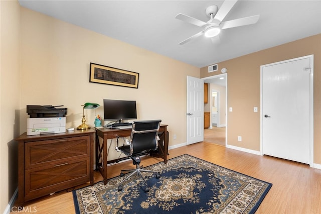 office area featuring visible vents, a ceiling fan, light wood-type flooring, and baseboards