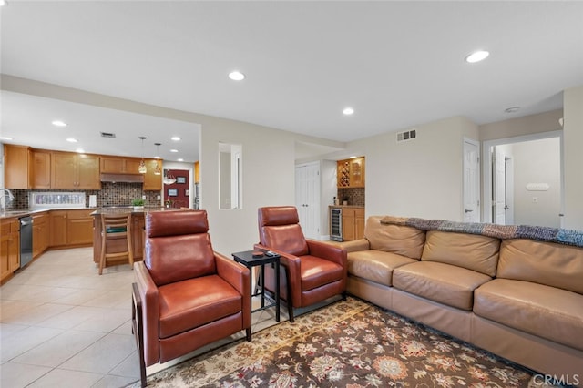 living room with light tile patterned flooring, visible vents, recessed lighting, and beverage cooler