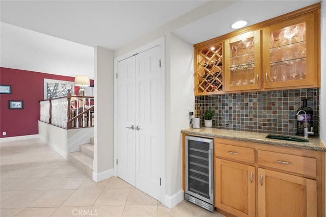 bar with a sink, backsplash, wine cooler, bar area, and stairs