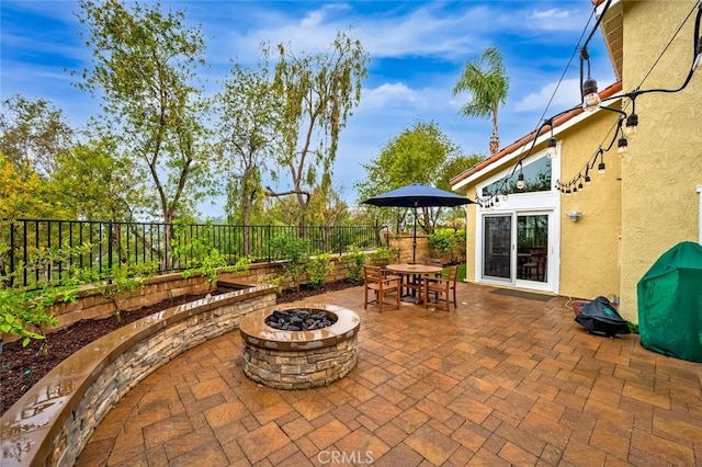 view of patio featuring outdoor dining space, an outdoor fire pit, and a fenced backyard