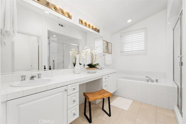 bathroom with visible vents, a garden tub, a sink, a shower stall, and vaulted ceiling