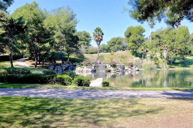 view of property's community featuring a lawn and a water view