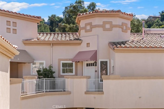 mediterranean / spanish home with stucco siding and a tiled roof