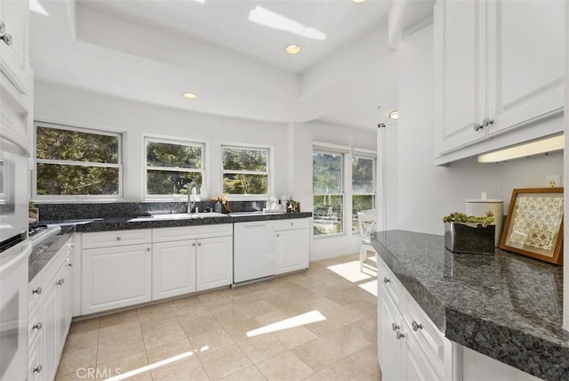 kitchen with dishwasher, recessed lighting, dark stone countertops, white cabinets, and a raised ceiling