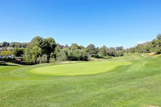 surrounding community featuring a lawn and golf course view