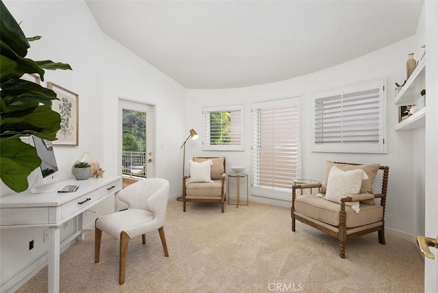 living area with light colored carpet, baseboards, and vaulted ceiling