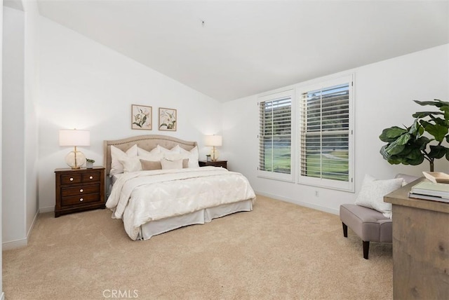 carpeted bedroom featuring baseboards and lofted ceiling