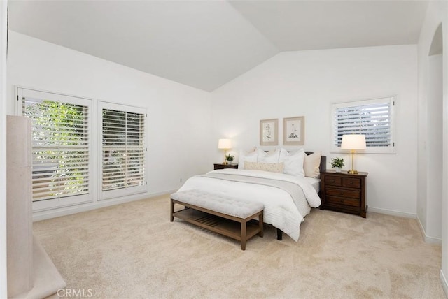 carpeted bedroom with lofted ceiling, multiple windows, and baseboards