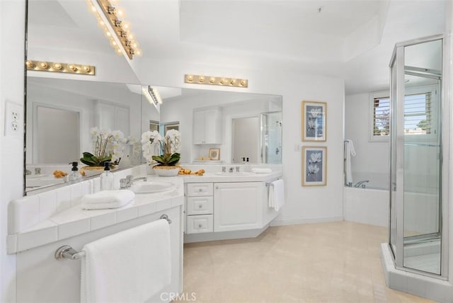 bathroom with a sink, a garden tub, a stall shower, and double vanity