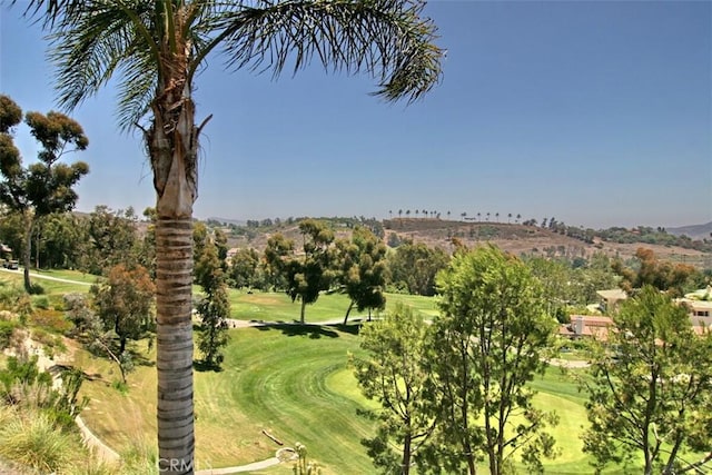 view of property's community featuring a lawn and view of golf course